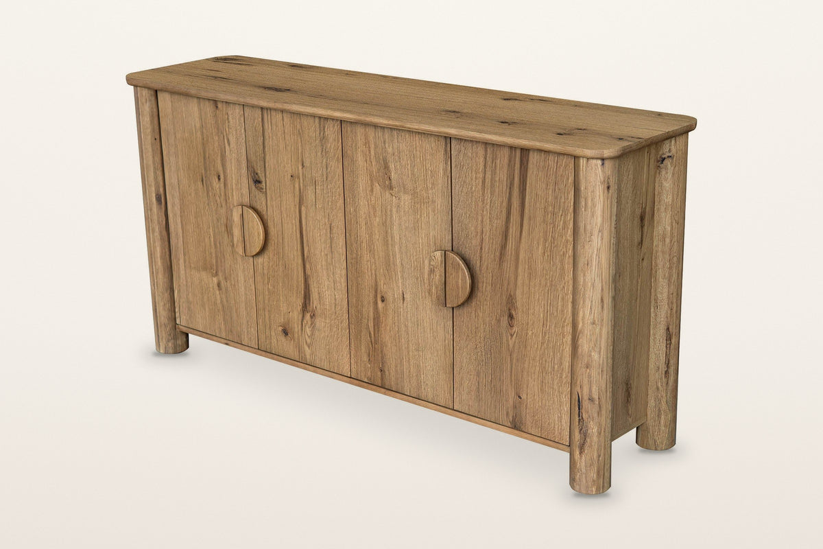 Atzara oak sideboard in Natural, three-quarter view on a warm white studio backdrop: four doors with a rustic oak grain