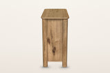Atzara Small sideboard in Natural, end view on a warm white studio backdrop: a flat oak end panel between two round column po