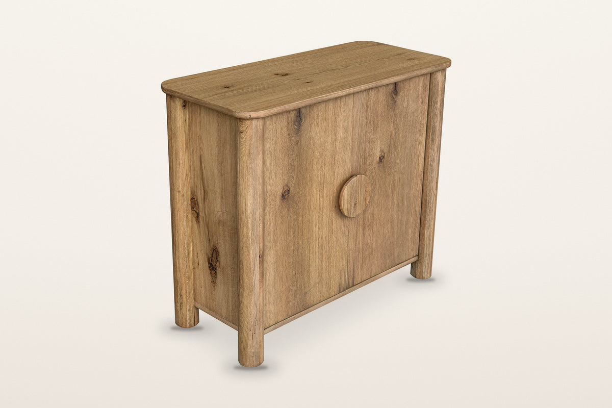Atzara Small oak sideboard in Natural, three-quarter view on a warm white studio backdrop: two doors with a rustic oak grain