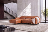 Wide view of the Andria cognac leather sectional with chaise and draped throw in a modern room