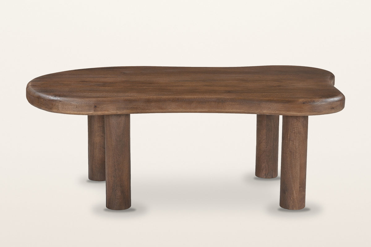 Bagnoregio coffee table in dark walnut from the front: a thick freeform slab with a rounded edge on four round post legs