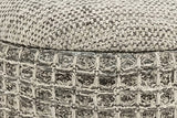 Close-up of the Balme pouf in Charcoal: the domed lid's fine weave over the rolled rim and the square waffle knit
