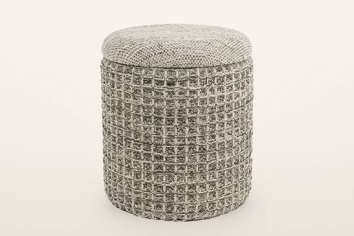 Balme round storage pouf in Charcoal on a warm white studio backdrop: a square waffle-knit drum with a domed knitted lid