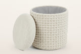 Balme pouf in Ivory with the lid lifted off and leaning on the drum: storage inside, lined in light grey fabric