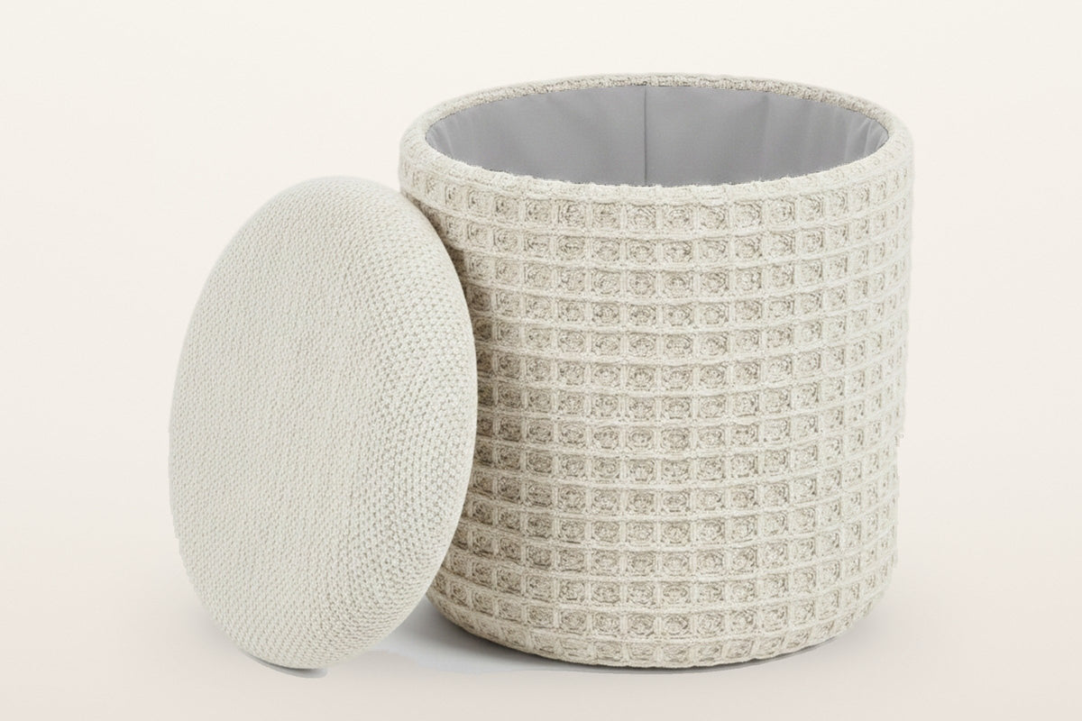 Balme pouf in Ivory with the lid lifted off and leaning on the drum: storage inside, lined in light grey fabric