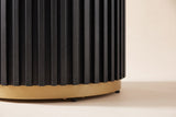Close-up of the black fluted drum base: fine vertical slats stepping onto a gold-finished metal ring with small black feet