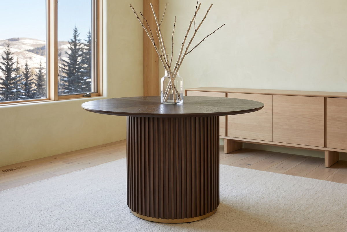 Bardolino round table in a foothills dining room with tall windows, a glass vase of birch twigs and a pale oak sideboard