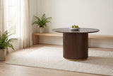 Bardolino round table in walnut in a bright dining nook, a bowl of pears at the centre, sheer curtains and a pale oak floor