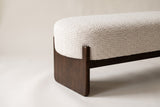 Close-up of the beige boucle seat corner, the square rubberwood post and the slab leg
