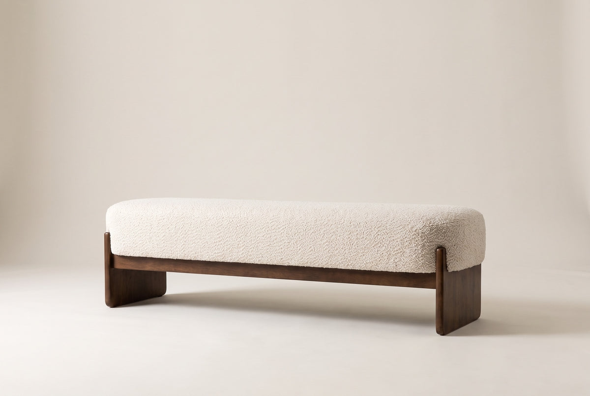 The Bassano bench in beige loop-yarn boucle on dark rubberwood slab legs, straight front view on an off-white studio background