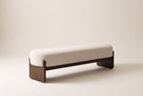 The Bassano bench in beige loop-yarn boucle on dark rubberwood slab legs, front three-quarter view on an off-white studio background