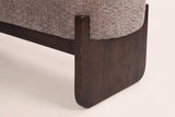 Close-up of a dark rubberwood slab leg with its softened corner and the post that holds the seat