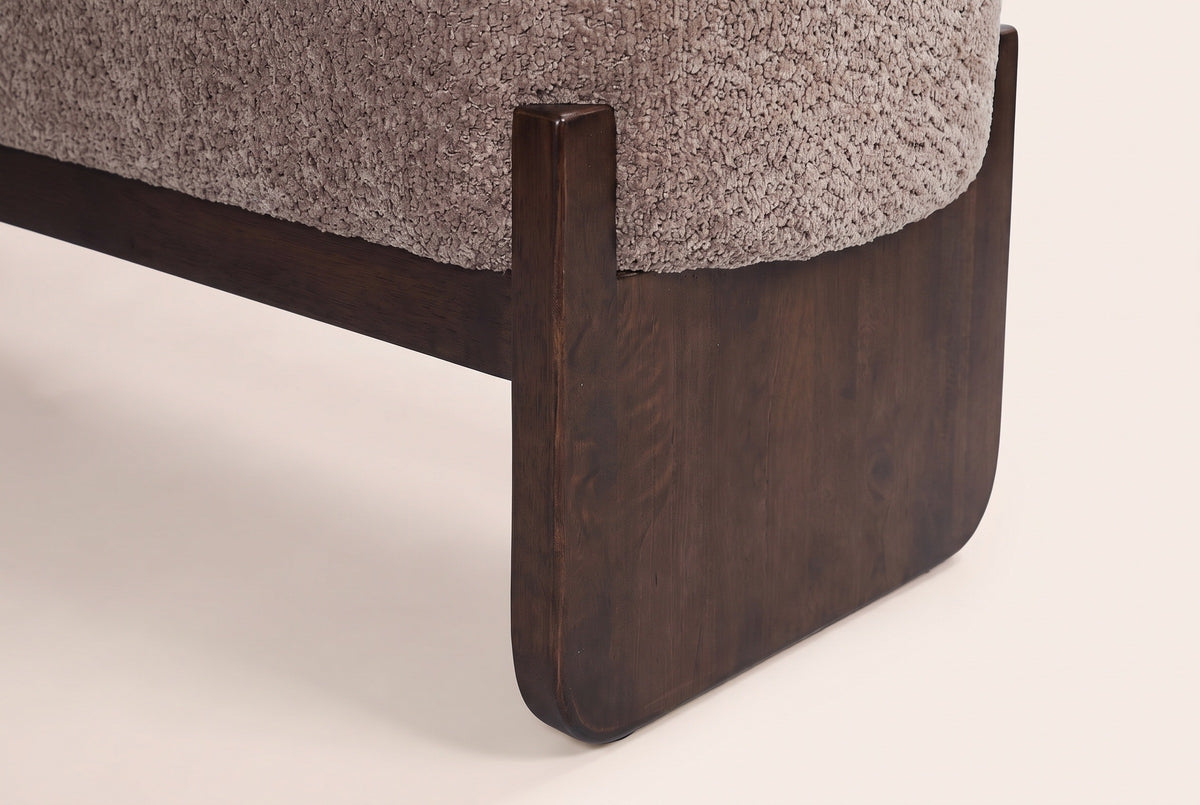 Close-up of a dark rubberwood slab leg with its softened corner and the post that holds the seat