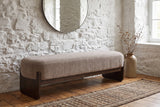 Bassano bench against a whitewashed stone wall in a Quebec City front hall, with a round mirror and a stoneware vase