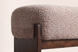 Close-up of the light brown loop-yarn boucle seat, a square rubberwood post and the front rail
