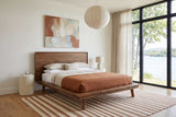 Bassiano bed in Warm Pecan in a bedroom in an Ottawa river house, three-quarter view, with warm white limewash