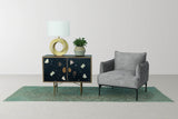 Bastien table lamp on a dark cabinet beside a grey accent chair