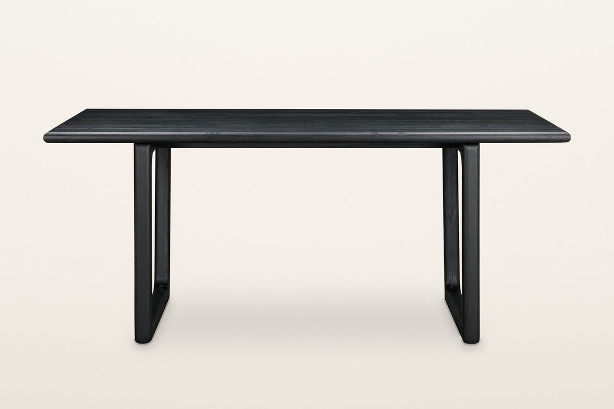 Bernalda dining table in Black, front view on a warm white studio backdrop
