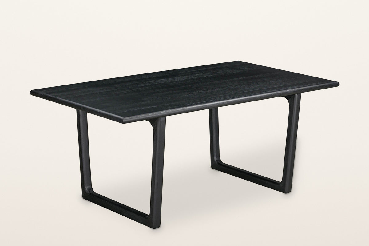 Bernalda sled base dining table in Black, three-quarter view on a warm white studio backdrop