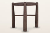Bettona side table, straight front view: a round top with four legs rising through notches in its rim