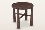 Bettona round side table in solid mango wood, dark walnut finish, three-quarter view on a warm white studio backdrop