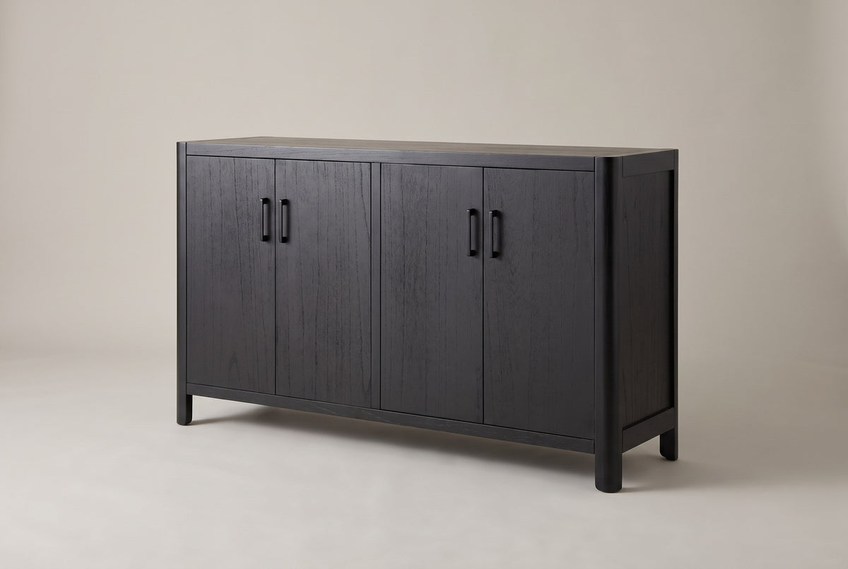 Bibbiena farmhouse 4-door sideboard in black, three-quarter view on a warm grey studio backdrop