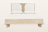 Bienno bed in Sand Wash acacia, front view from the foot on a warm white studio backdrop: the box rail on two flat paddle fee
