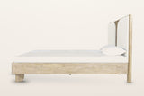 Side view of the Bienno bed on a warm white studio backdrop: the deep box rail