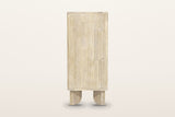Side view of the Bienno chest in Sand Wash on a warm white studio backdrop: a plain acacia side panel over two flat paddle le
