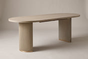 Bobbio fluted double-pedestal dining table in Light Natural, three-quarter view on a warm grey studio backdrop