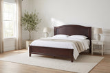 Bolsena panel bed in espresso made up with white linen, in a bright bedroom with white nightstands and an olive tree