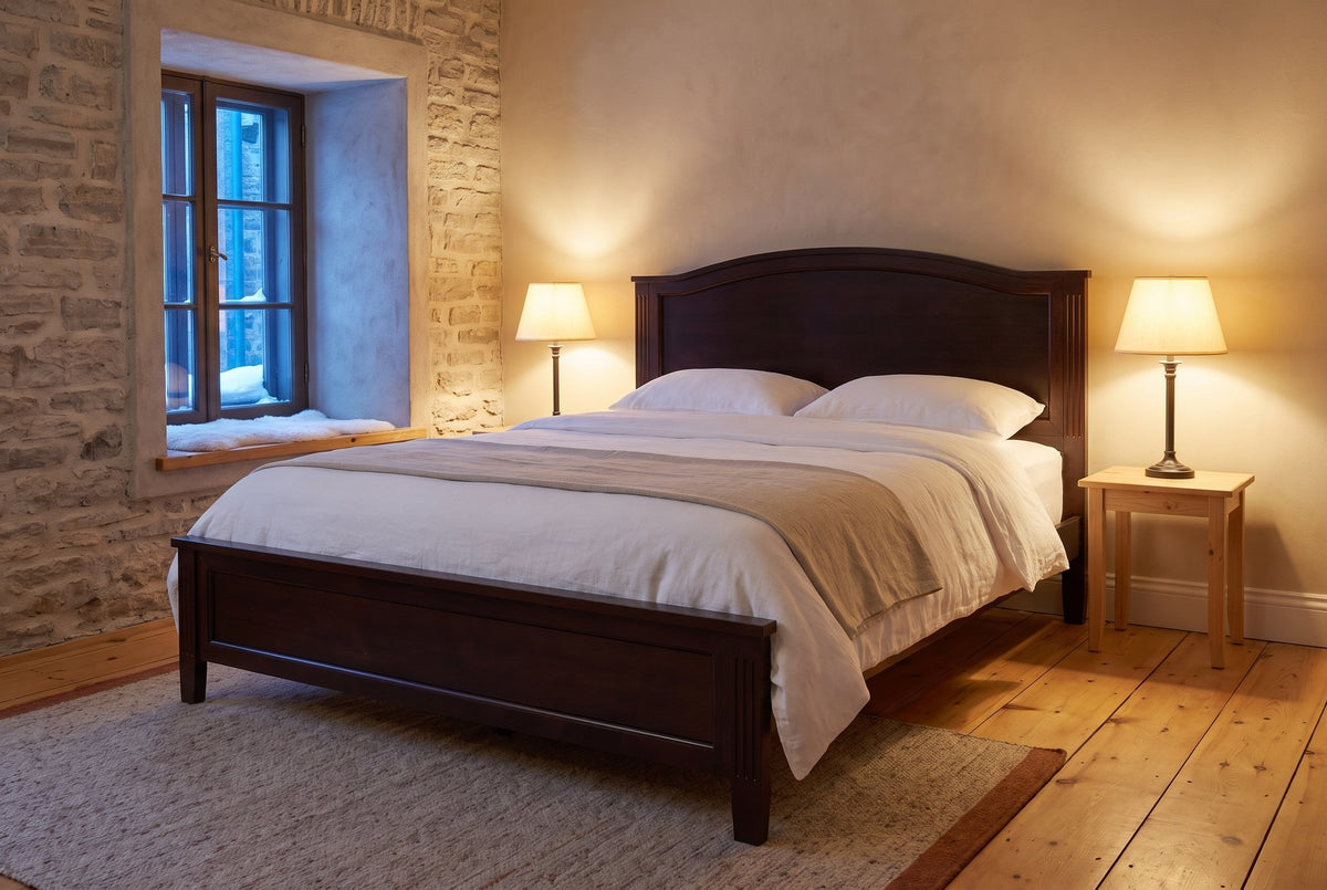 Bolsena panel bed in a stone-walled bedroom at dusk, two table lamps lit