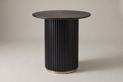 Bolzano round counter height table in black, three-quarter view on a warm grey studio backdrop