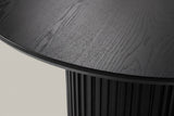 Close-up of the black-stained ash veneer top, its thin edge and the top of the fluted drum below