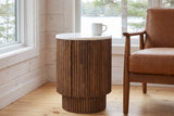Bomarzo side table in walnut beside a cognac leather lounge chair in a Muskoka cottage, a white mug on the marble