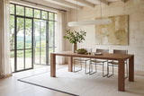 Bominaco dining table in Brown in a dining room with a pale limestone wall