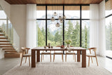 Bominaco dining table in Brown in a Squamish house: a tall glass wall to the granite cliff and firs, a floating oak stair