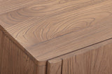 Close-up of the Bominaco sideboard in Brown: the softly rounded front corner of the top above a plain slab door