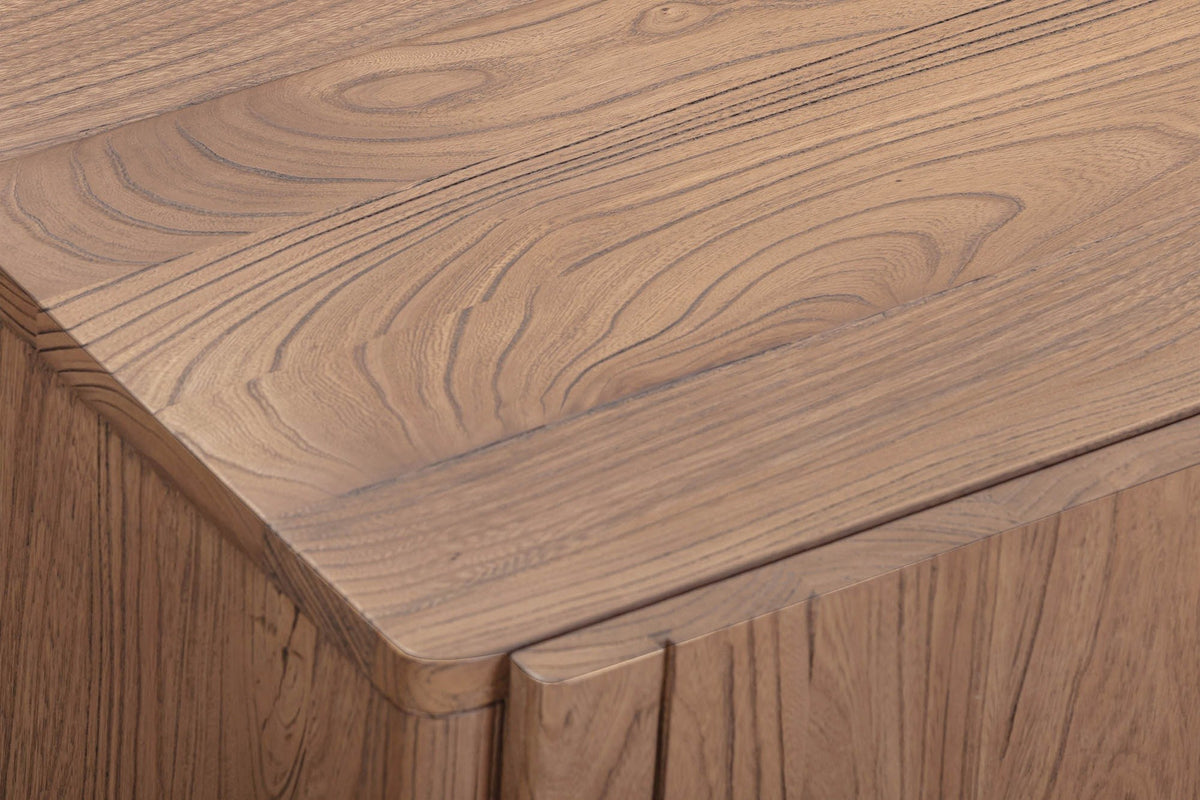 Close-up of the Bominaco sideboard in Brown: the softly rounded front corner of the top above a plain slab door