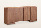 Bominaco wood sideboard in Brown, three-quarter view on a warm white studio backdrop: four plain slab doors with no handles