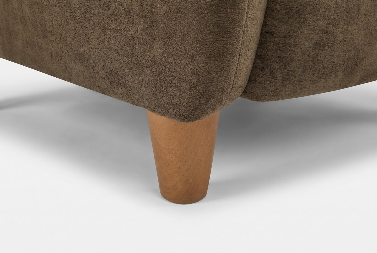 Close-up of a tapered solid birch leg in a teak finish under the velvet corner
