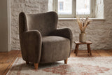 Bormio chair against an old limestone wall with snow outside the window, on wide pine floorboards