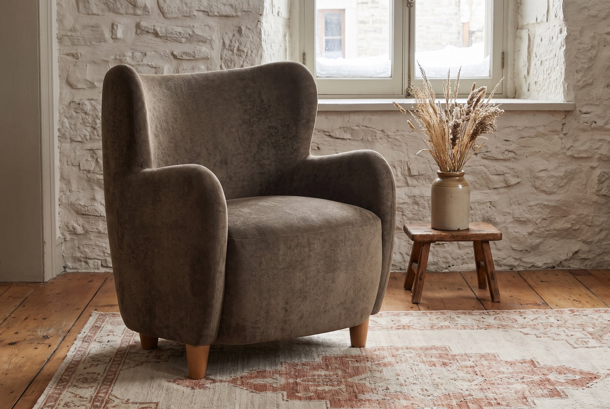 Bormio chair against an old limestone wall with snow outside the window, on wide pine floorboards