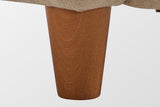 Close-up of a tapered solid birch leg in a teak finish under the velvet corner (Light Camel)