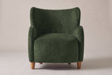 Bormio wingback chair in olive green velvet, straight front view on a studio backdrop