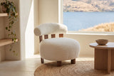 Brescia boucle accent chair on a round jute rug in a bright lake house, the lake and hills through the window (Off White)