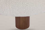 Close-up of a round walnut-finished birch front leg under the curly Off White boucle seat