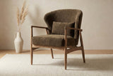 Briar Nettle fabric accent chair on a cream rug beside a vase of pampas grass