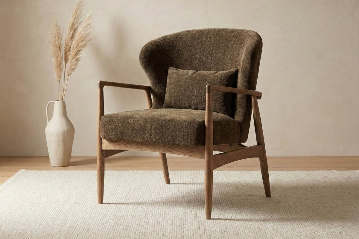 Briar Nettle fabric accent chair on a cream rug beside a vase of pampas grass