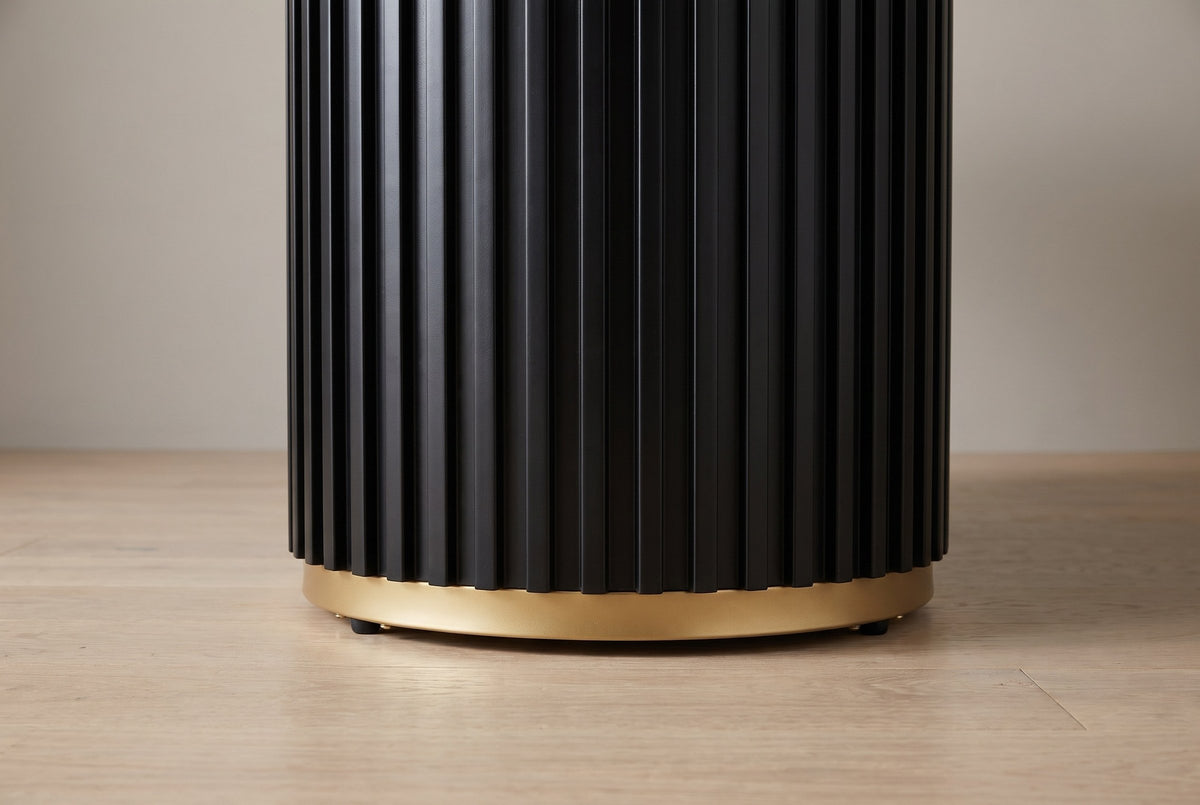 Close-up of the base: tall black fluted slats stepping down onto a slim gold-finish ring with small black feet